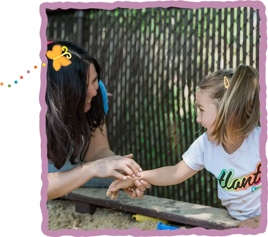 A woman and girl play in a sandbox.
